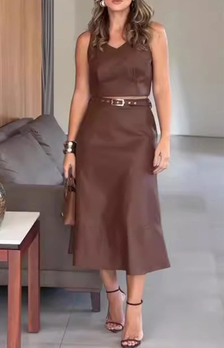 woman in a brown leather outfit standing in a room