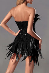A woman wearing a black strapless sequined mini dress with feather accents, shown from the back.