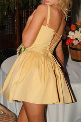 Back view of a woman in a yellow dress with lace-up back