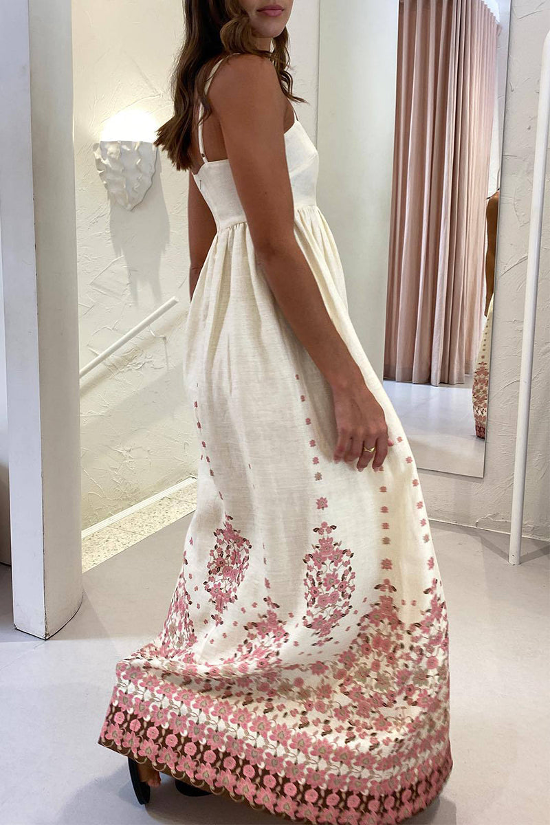 Woman wearing a cream maxi dress with pink floral print, seen from the back