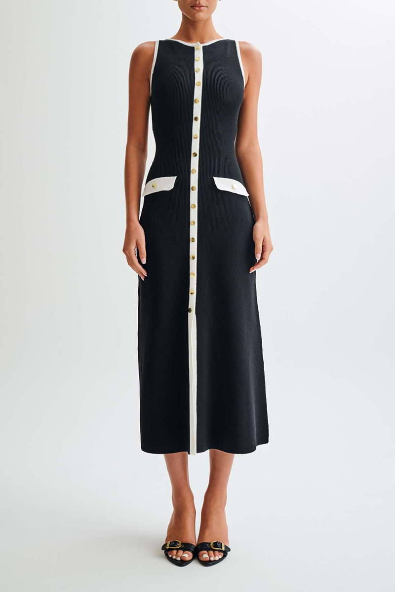 woman wearing a black and white ribbed knit midi dress with gold buttons and pockets against a white background