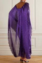 Back view of a woman in a purple metallic pleated maxi dress with dramatic cape sleeves.