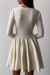 The back of a woman wearing a long-sleeved ivory fit-and-flare dress.