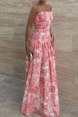 Woman wearing a pink and white patterned strapless maxi dress.