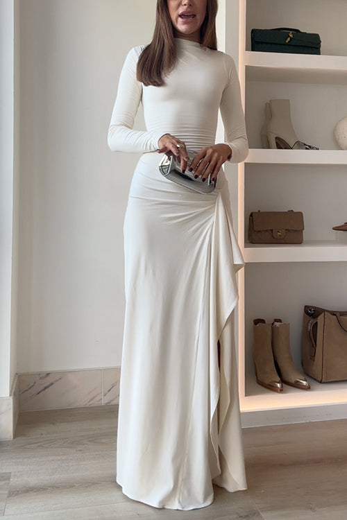 A woman holds a silver clutch in front of her ivory dress.
