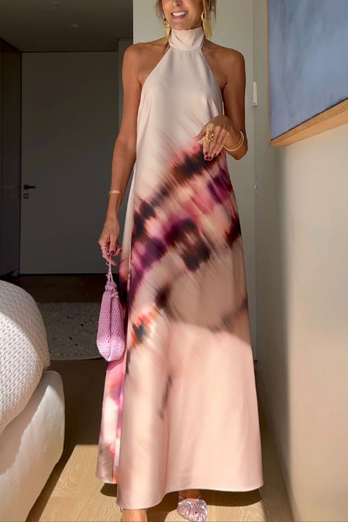 Woman wearing a long pink and purple floral print halter neck dress