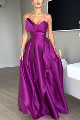 Full shot of a woman modeling a purple satin gown with a draped bodice and a flowing A-line skirt.
