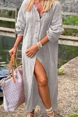 woman wearing a grey long button-down dress with a high slit and a tote bag