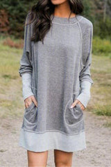 woman wearing a gray long-sleeved dress with pockets