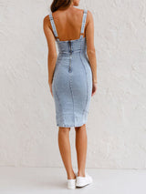 Back view of a woman wearing a light blue denim sleeveless sheath dress with a zipper closure.