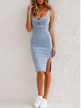 Woman wearing a light blue denim sleeveless sheath dress with a scoop neck, zipper closure, and high slit, posing with hand on head.