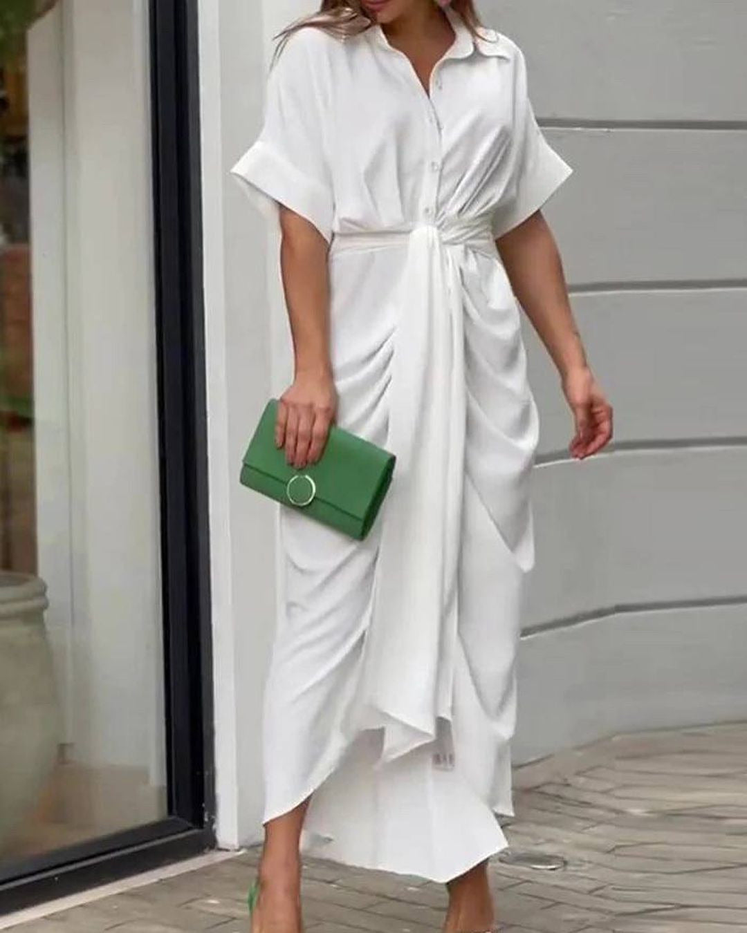 A woman in a white dress with a green clutch