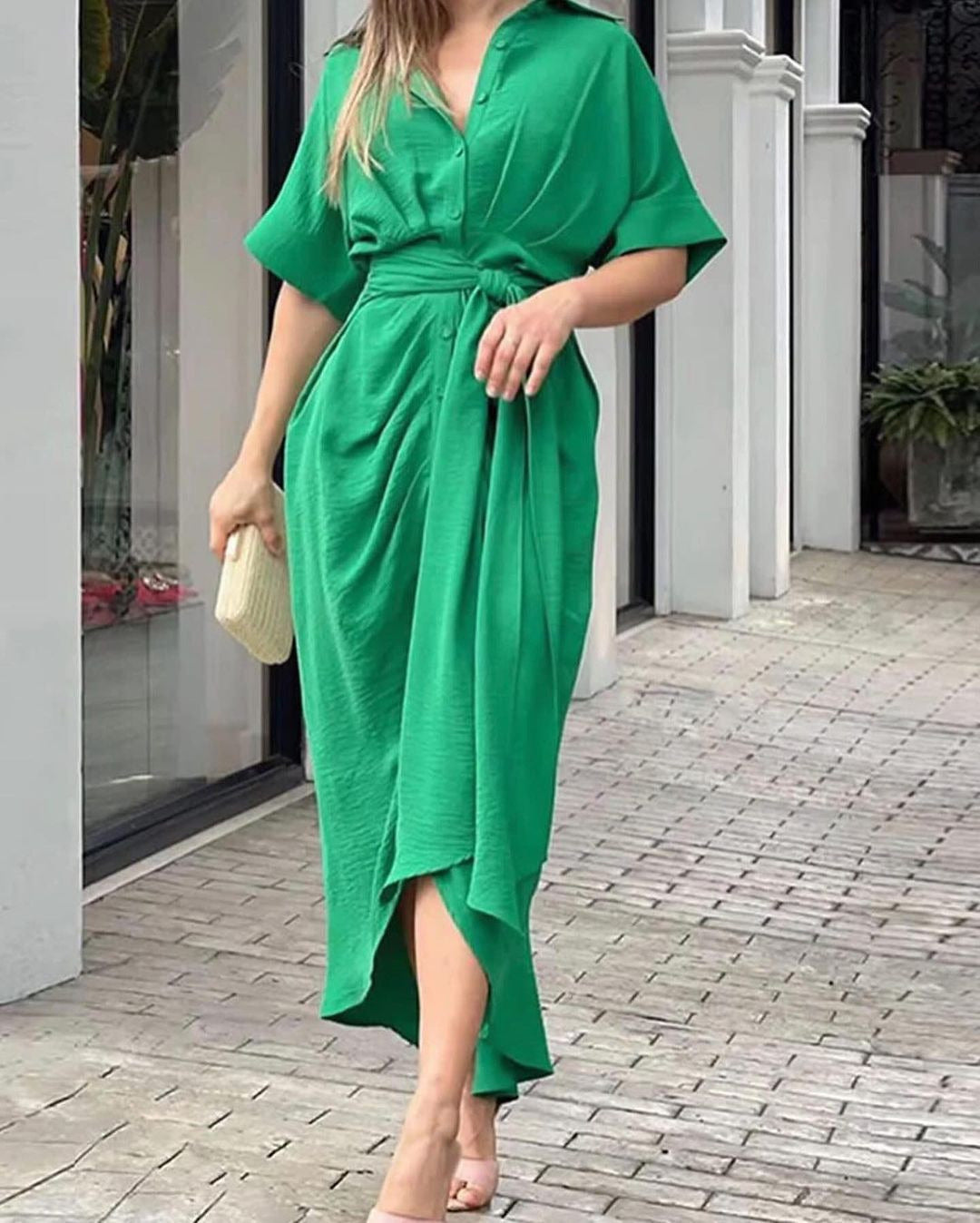 Woman wearing a green crinkled shirt dress with a tie waist and short sleeves