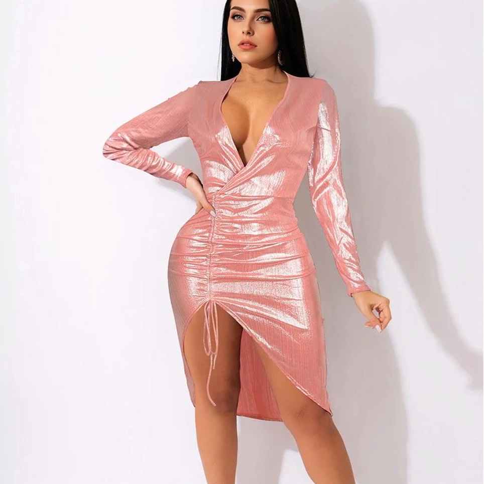 Woman wearing a pink metallic ruched dress with a deep V-neck and long sleeves.