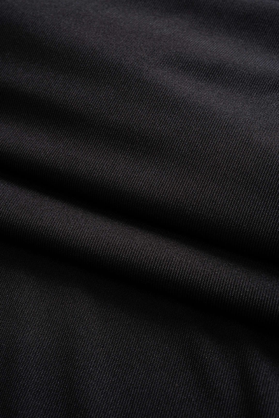Close-up of the ribbed knit fabric of a black dress.