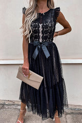 woman in a black lace and tulle midi dress with a bow