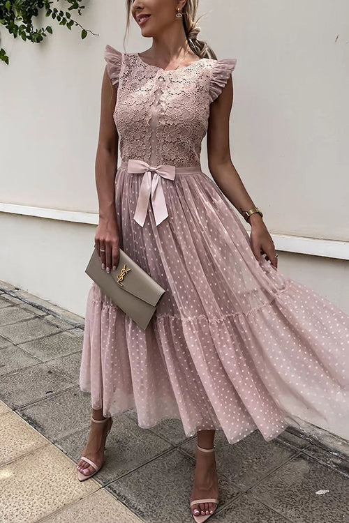 woman in a pink lace and tulle midi dress with a bow