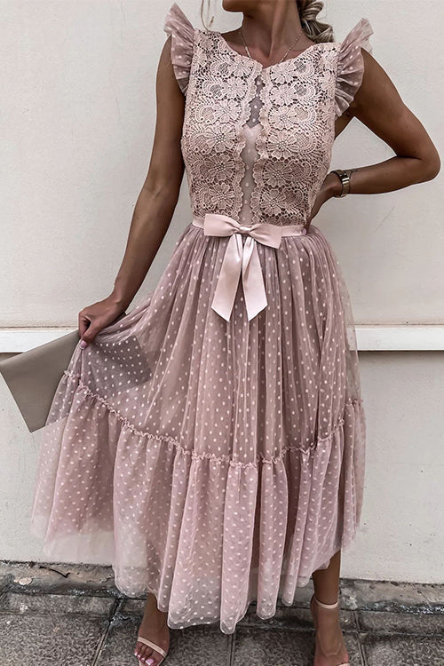 woman in a pink lace and tulle midi dress with a bow