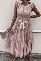 woman in a pink lace and tulle midi dress with a bow