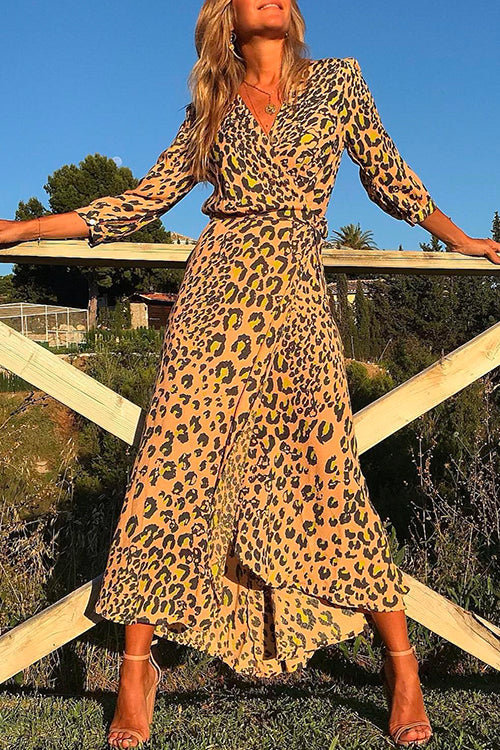 woman in leopard print wrap dress standing outdoors