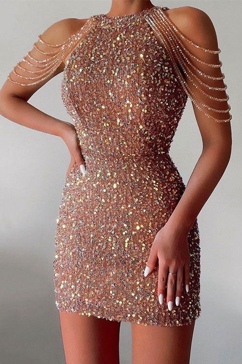 A woman in a rose gold sequined mini dress with beaded shoulder straps.