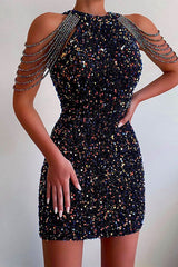 A woman in a navy blue sequined mini dress with beaded shoulder straps.