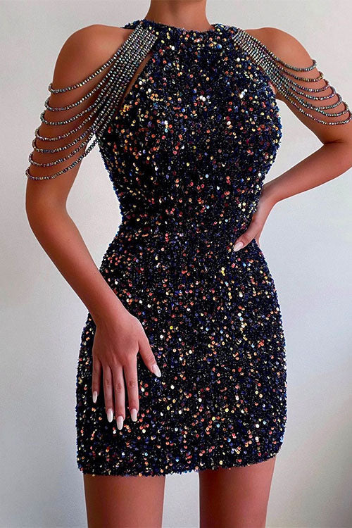 A woman in a navy blue sequined mini dress with beaded shoulder straps.