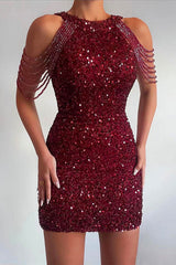 A woman in a burgundy sequined mini dress with beaded shoulder straps.