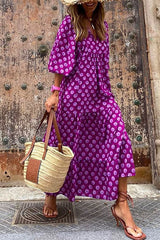 Woman wearing a purple polka dot dress with puff sleeves and a tiered skirt, carrying a straw bag.