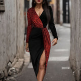 Woman wearing a black and red sequined wrap dress with a high slit, standing in an alley.