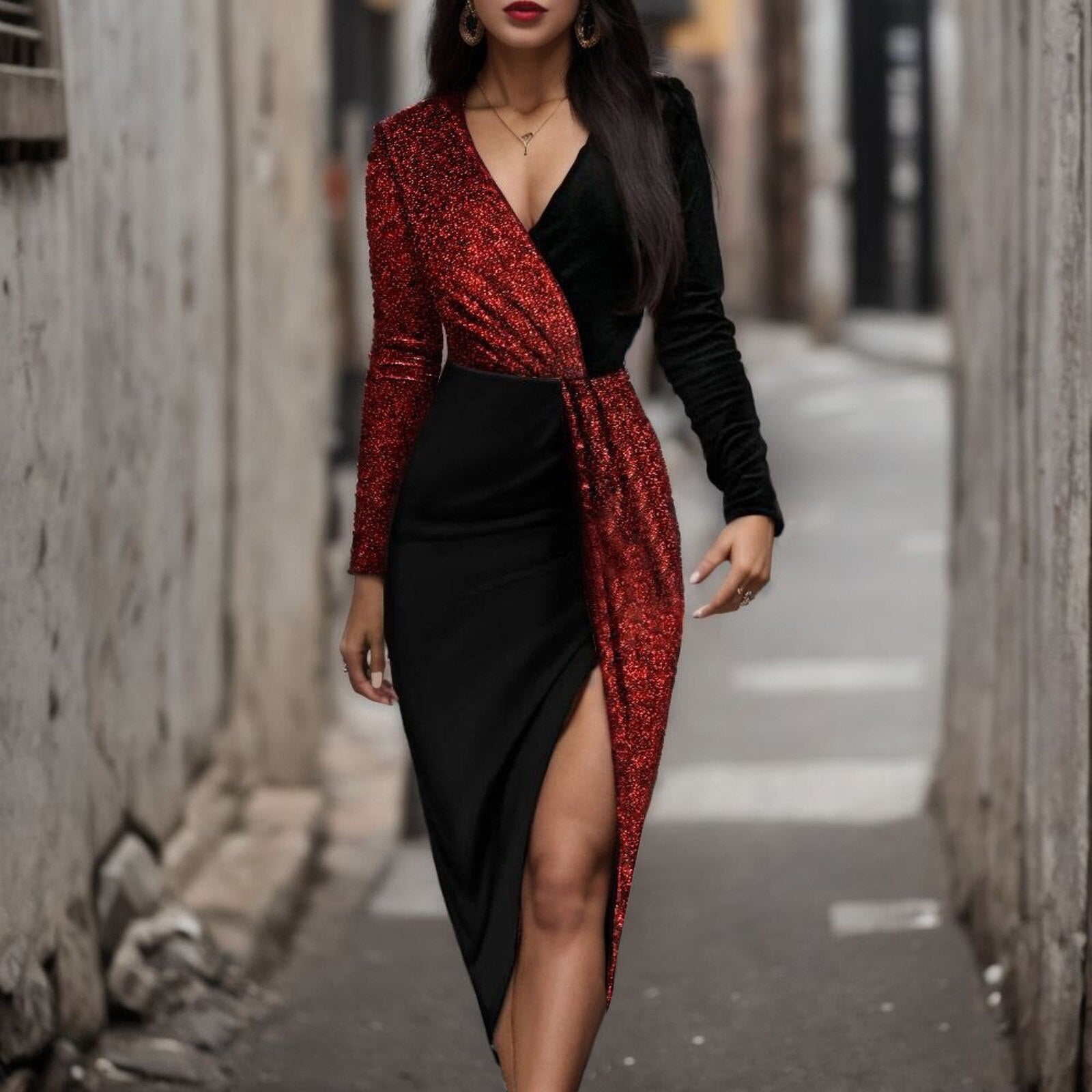 Woman wearing a black and red sequined wrap dress with a high slit, standing in an alley.