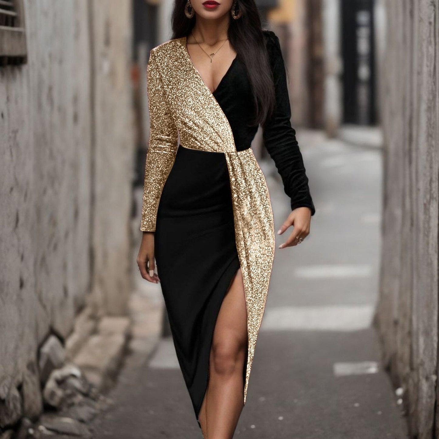 Close-up of a black and gold sequined wrap dress with a high slit.