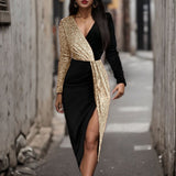 Close-up of a black and gold sequined wrap dress with a high slit.
