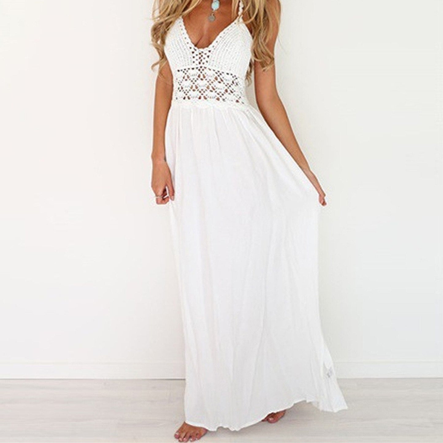 Woman in a white crochet halter maxi dress