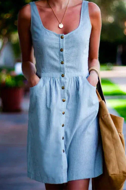 woman wearing a light blue and white striped seersucker dress with a scoop neck and button-down front