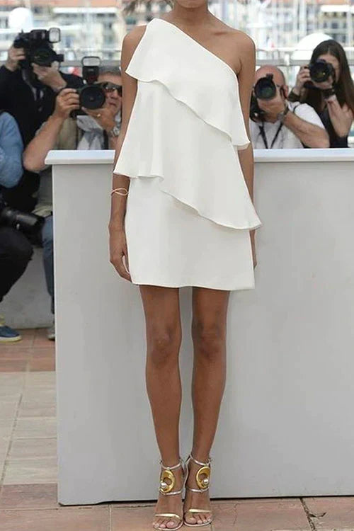woman in a white one-shoulder ruffled dress