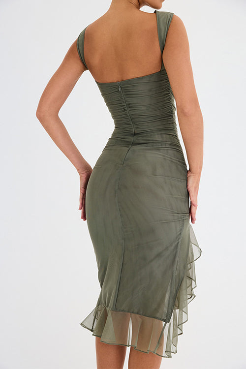 Back view of a woman in an olive green ruched mesh dress, showing the zipper closure and ruffled hem.