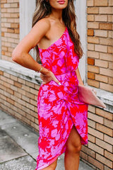 close-up of a woman wearing a pink and red floral one-shoulder sheath dress, showing the ruched detail and tulip hem
