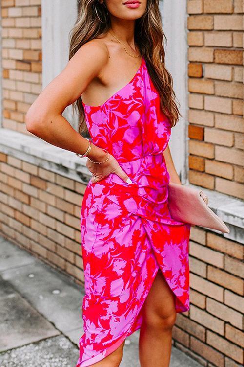 close-up of a woman wearing a pink and red floral one-shoulder sheath dress, showing the ruched detail and tulip hem
