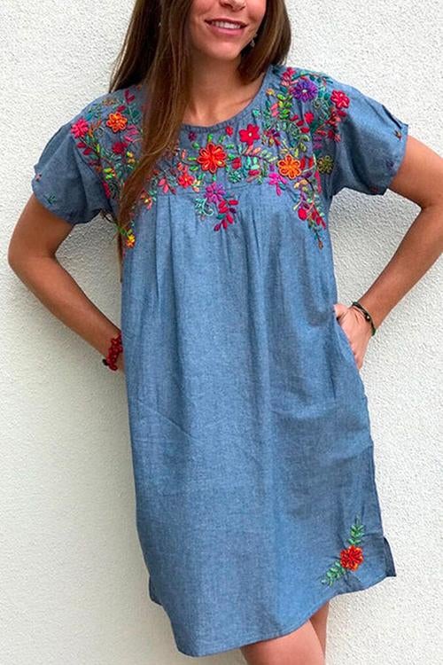 Woman wearing a light blue embroidered floral shift dress