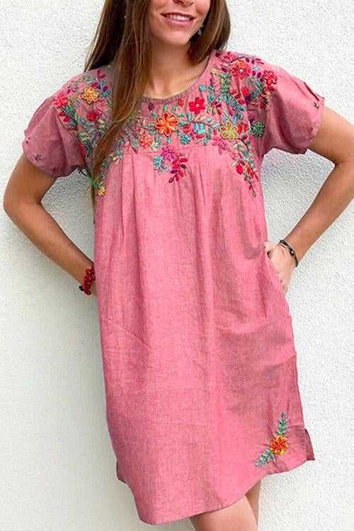 Woman wearing a dusty rose embroidered floral shift dress