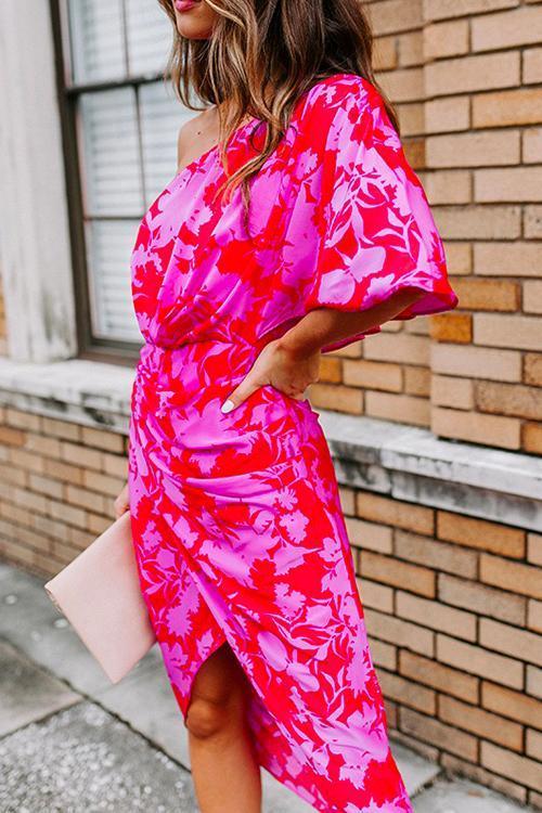 side view of a woman in a pink and red floral one-shoulder sheath dress
