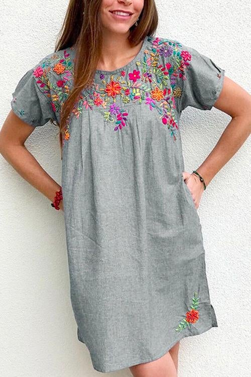 Woman wearing a gray embroidered floral shift dress