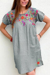 Woman wearing a gray embroidered floral shift dress