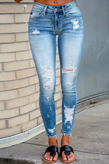 woman wearing light blue ripped skinny jeans with frayed hem and black sandals