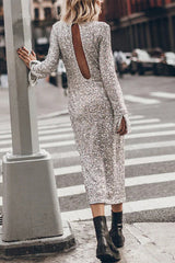 Back view of a woman in a silver sequined midi dress with a deep V-shaped cutout on the back and long bell sleeves.