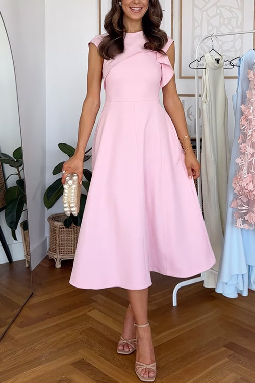 Rear view of a woman in a pink midi dress with cap sleeves and a pleated skirt, standing in a room with plants and clothing racks.