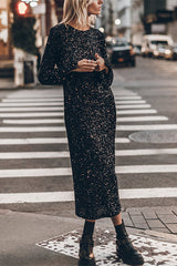 Woman wearing a black sequined midi dress with long bell sleeves and black combat boots, standing on a city street with crosswalk.