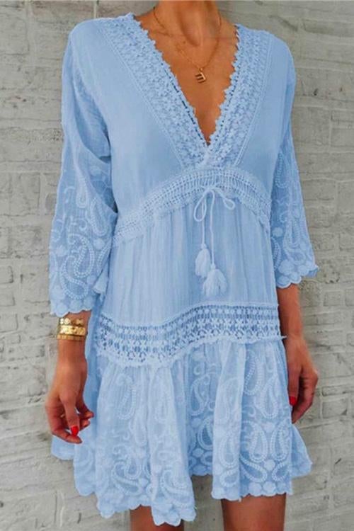 A woman modeling a light blue bohemian-style dress with lace trim and paisley print.