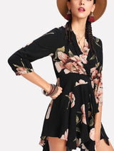 woman in a black floral wrap dress with a hat